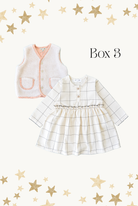 Children's outfit with checkered dress and vest on a white background with gold stars.